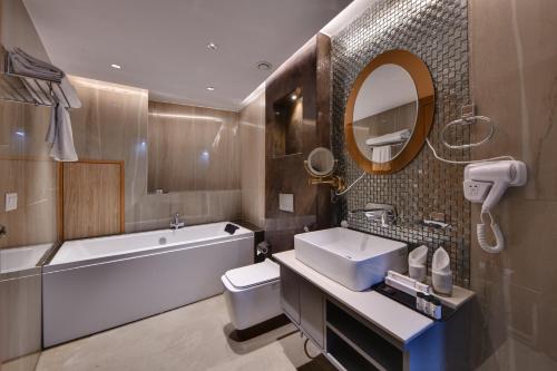阿姆利则Quality Inn Elite, Amritsar的带浴缸、盥洗盆和卫生间的浴室