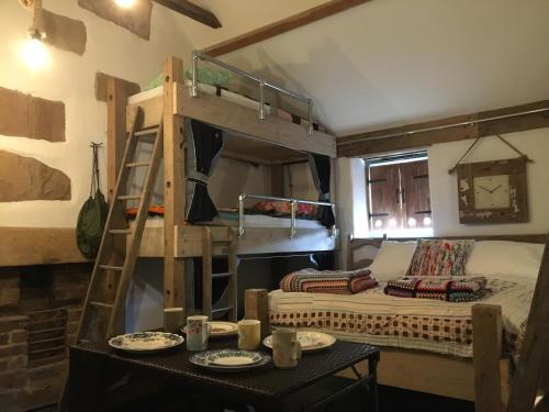 马特洛克Matlock Glamping Rooms的客房设有双层床和一张带餐具的桌子。