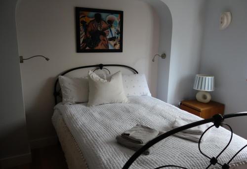 布里斯托Stunning guest house in Frenchay的一间卧室配有一张带白色床单和照片的床
