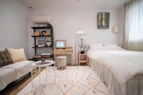 首尔Near Hongdae CozyBrickhaus的一间带两张床和一张沙发的客厅