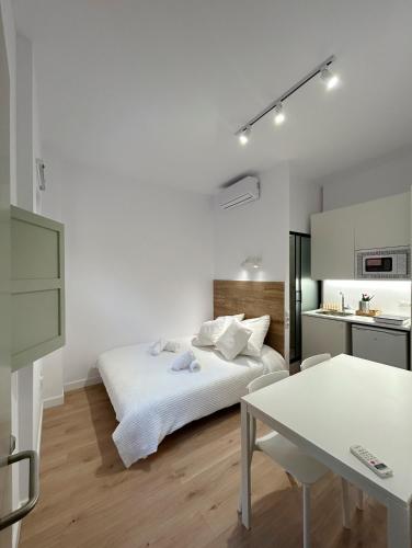 特拉萨SD Habitación céntrica con baño y minicocina的白色卧室配有床和桌子