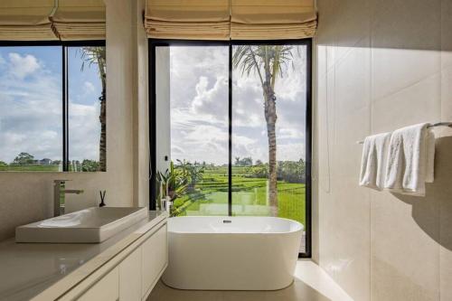 勒吉安NEW Luxury 3BR, Jacuzzi Rooftop Rice Field, Staff的带浴缸的浴室和大窗户