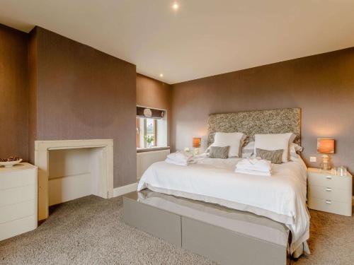 索厄比布里奇3 Bed in Halifax 90209的卧室配有一张白色大床和壁炉