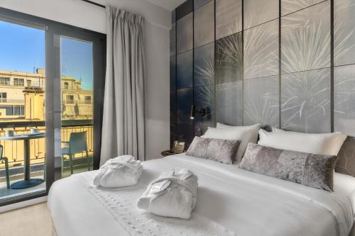沃洛斯Azur Hotel Volos的卧室配有白色的床和大窗户