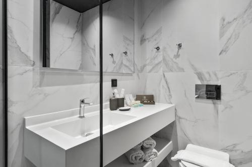 沃洛斯Azur Hotel Volos的白色的浴室设有水槽和镜子