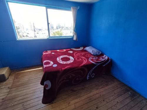 维纳德马Casa yeici的蓝色客房,配有一张带红色毯子的床