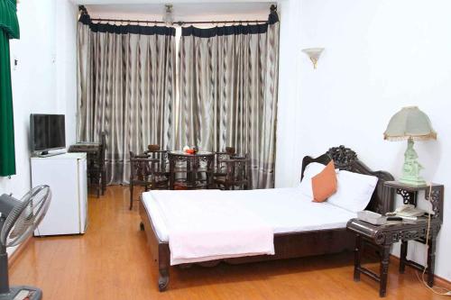 河内HOÀNG CƯỜNG HOTEL 15 Nguyễn Thái Học的卧室配有一张床和一张桌子及椅子
