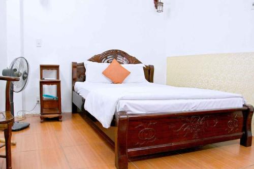河内HOÀNG CƯỜNG HOTEL 15 Nguyễn Thái Học的一间卧室配有带白色床单和橙色枕头的床