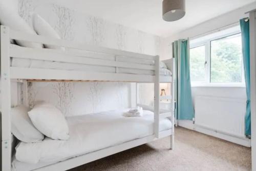 曼彻斯特Newly renovated house near Trafford Centre的窗户客房内的一张白色双层床