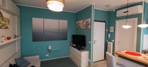 库尼奥L'alloggetto sul Corso的客厅设有蓝色的墙壁和电视。