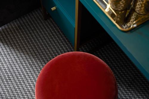 伦敦The Portico Hotel的一张红色椅子坐在桌子前