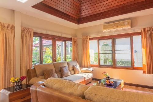 南芭堤雅Bali Haven 3BR PrivatePool Villa的带沙发的客厅和部分窗户。