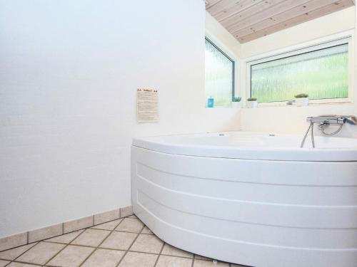 格雷诺8 person holiday home in Grenaa的白色的浴室设有浴缸和窗户。