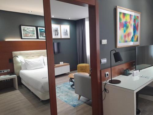 圣塞瓦斯蒂安Hotel Silken Amara Plaza的酒店客房配有一张床、一张桌子和一把椅子。