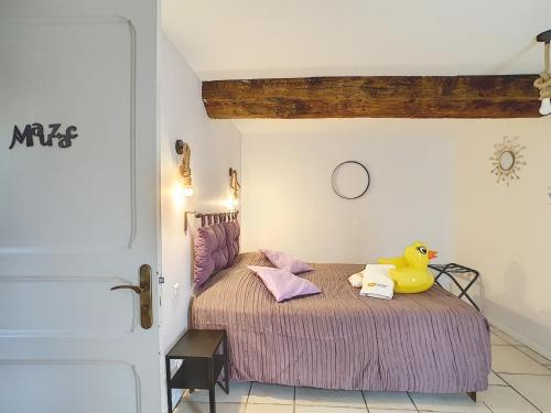 卡斯泰尔诺达里Le Grand Bassin的卧室配有黄色橡皮鸭,坐在床上
