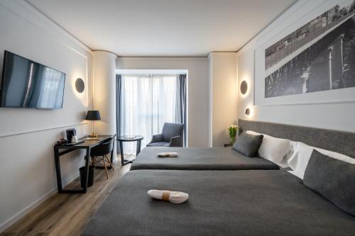 瓦伦西亚孔克立多酒店的酒店客房配有一张床、一张书桌和一台电视。