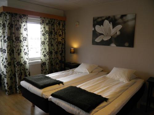 哥德堡欧罗维酒店的一间卧室设有两张床,窗户配有窗帘