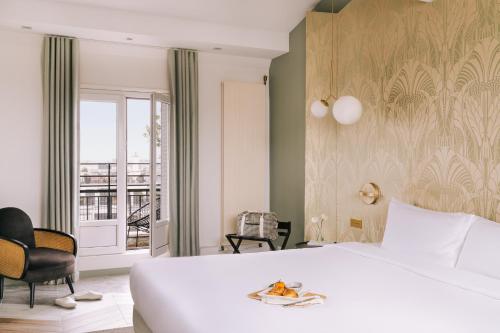 巴黎Atala powered by Sonder的一间带一张白色大床的卧室和一个阳台