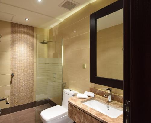 吉达哈亚特赫拉酒店的一间带卫生间、水槽和镜子的浴室