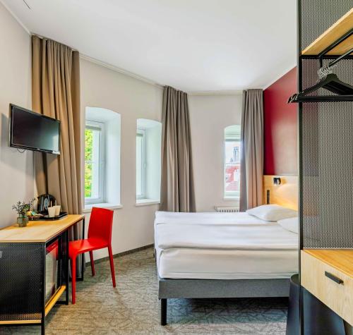 塔林Rija Old Town Hotel的酒店客房设有一张床、一张书桌和一台电视机。