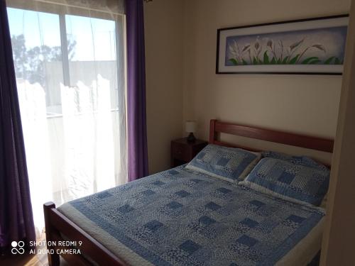 埃尔基斯科Cabanas Piedras Preciosas的一间卧室配有一张带窗户和毯子的床