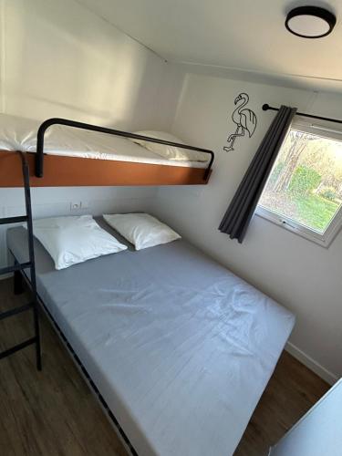 ChauzonCamping Beaussement LIBERTY climatisé的一间小卧室,配有双层床和窗户
