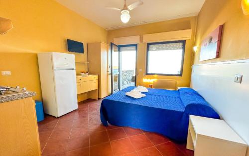 斯廷蒂诺佩罗塞塔公寓式酒店的一间卧室配有蓝色的床和冰箱