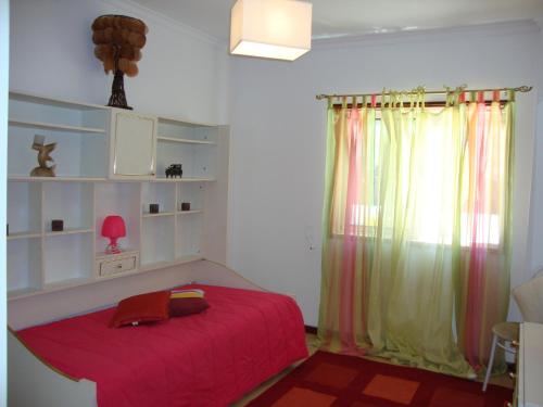 厄米森德Apartamento Aracelli的一间卧室设有红色的床和窗户。