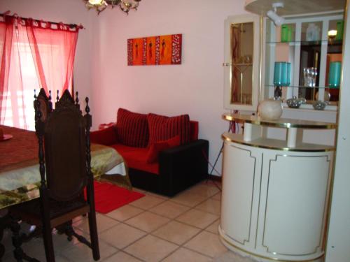 厄米森德Apartamento Aracelli的客厅配有红色的沙发和桌子