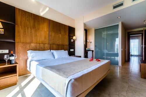 阿利坎特种植园高尔夫度假酒店的一间卧室配有一张大床和木制床头板