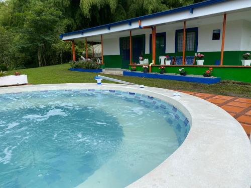 萨兰托Macondo casa café的一座带房子的庭院内的大型游泳池