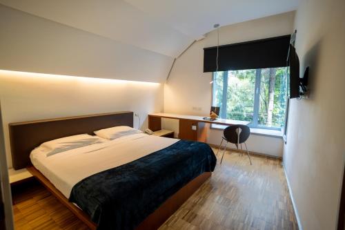 罗马布拉克酒店的一间卧室配有一张床、一张书桌和一个窗户。
