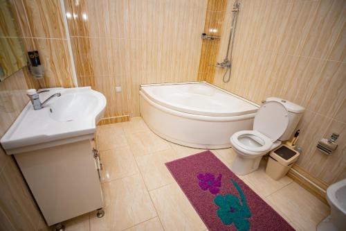 杜尚别VATAN DUSHANBE HOTEL的浴室配有卫生间、盥洗盆和浴缸。