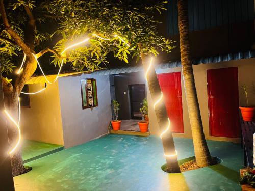 蓬蒂切里Hostel kuruku santhu colive的一间设有棕榈树和灯光的游泳池的客房