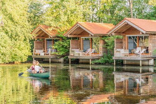 Jetzendorf巴伐利亚波豪斯酒店的河上两座小屋前划独木舟的女人