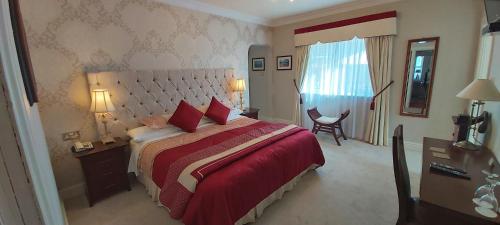 特拉利溪流庄园酒店的一间卧室配有一张带红色毯子的大床