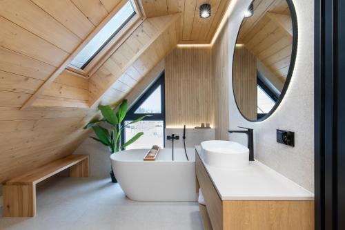 克鲁斯兹考采Stylchyn Park - Czorsztyn Exclusive的一间带大型白色浴缸和大镜子的浴室