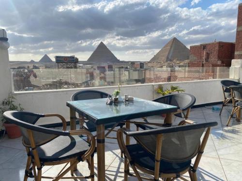 开罗Eagles Pyramids View的屋顶上一张桌子和椅子,上面有金字塔