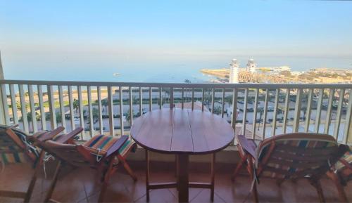 艾因苏赫纳Porto Sokhna Pyramids Apartments的海景阳台上的桌椅