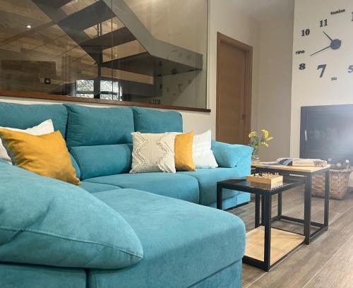 Villar de PlasenciaVillabellosa的客厅配有一张蓝色的沙发,配有一张桌子