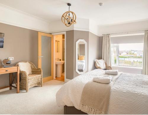波特拉什Larkhill House的一间卧室配有一张床、一张书桌和一个窗户。