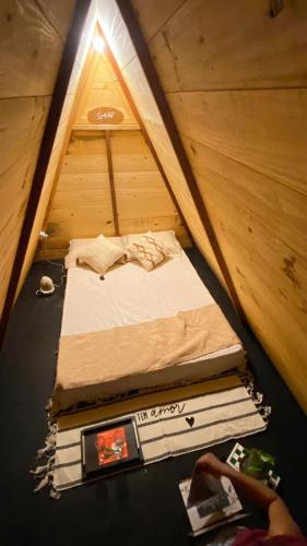 A Chave da Montanha的一张位于帐篷内的床位,里面摆放着一叠书