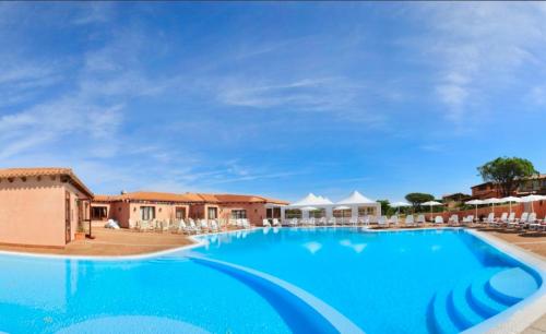 Vignola MareResidence with swimming-pool in Vignola Mare的一座带椅子的度假村的大型游泳池