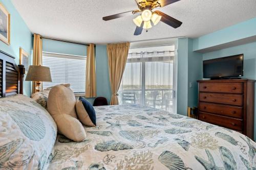 默特尔比奇Oceanfront Get Away的一间卧室配有一张床和吊扇