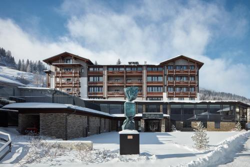 索内纳尔佩·纳斯费尔德Hotel Wulfenia 4S - Adults Only的雪上有雕像的建筑