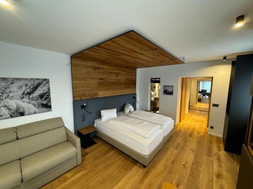海利根布卢特卡尔特纳尔霍夫酒店的一间卧室配有一张床和一张沙发