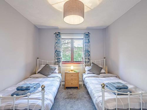 Ffestiniog4 Bed in Porthmadog 81060的带窗户的客房内设有两张单人床。