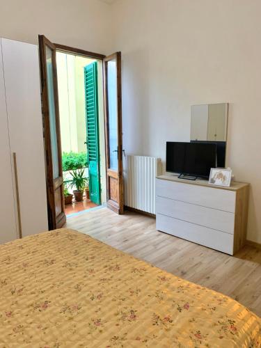 蒙特卡蒂尼泰尔梅Appartamento Meri, Montecatini Terme的一间卧室配有一张床和一个带镜子的梳妆台