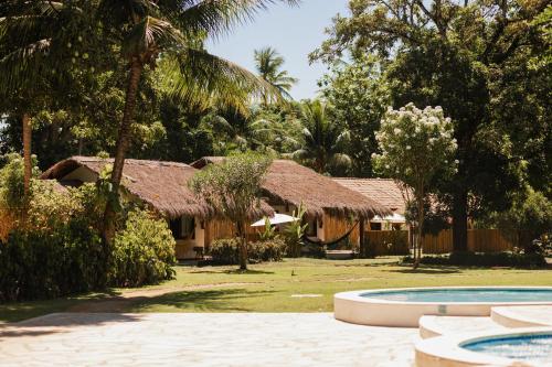 普拉亚多斯卡内罗斯班格多哥美罗若旅馆的一座带游泳池的度假村和一座树木繁茂的建筑