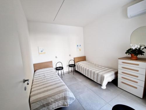 利多迪耶索罗Dainese Apartments, Casa Miriam的一间卧室配有一张床、梳妆台和椅子